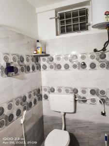 a bathroom with a toilet and plates on the wall at PY Home Stay in Puducherry