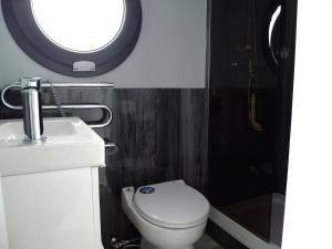 a bathroom with a toilet and a sink and a window at Floating freedom by the Dodekalitten in Torrig