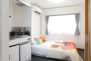 a small bedroom with a bed and a window at oyasumi manga&hotel 难波南店 in Osaka