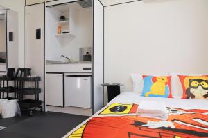 a bedroom with a king sized bed and a kitchen at oyasumi manga&hotel 难波南店 in Osaka