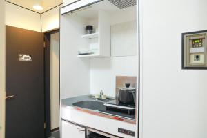 a kitchen with a sink and a microwave at oyasumi manga&hotel 难波南店 in Osaka +23 photos
