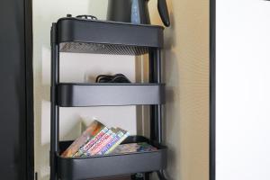 a black book shelf with books on it at oyasumi manga&hotel 难波南店 in Osaka