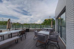 Un patio con mesas y sillas en un balcón. en Atour Hotel Guangzhou Zhongcun Hanxi Changlong Metro Station, en Guangzhou