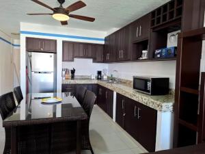a kitchen with a table with chairs and a refrigerator at Condominio Xaman Ha 7107 in Playa del Carmen