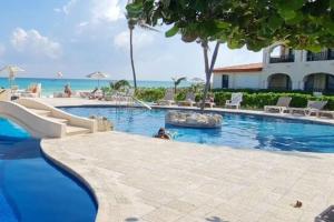 a swimming pool at a resort near the ocean at Condominio Xaman Ha 7107 in Playa del Carmen