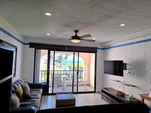 a living room with a couch and a ceiling fan at Condominio Xaman Ha 7107 in Playa del Carmen
