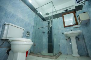 a bathroom with a toilet and a sink and a shower at Lucky Seven Hikkaduwa in Hikkaduwa