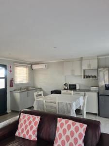 a living room with a couch and a kitchen at Palm Bliss Self Catering Accommodation in Durban