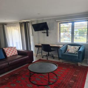 a living room with a couch and a table at Palm Bliss Self Catering Accommodation in Durban
