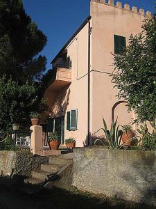 a white building with plants in front of it at Villa San Giuseppe in Porto Azzurro