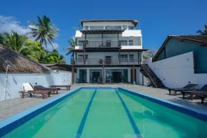 a house with a swimming pool in front of a house at Lucky Seven Hikkaduwa in Hikkaduwa