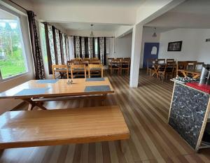 a dining room with tables and chairs in a room at Shail Shikhar Heritage Inn in Joshīmath