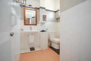 a white bathroom with a sink and a toilet at Lucky Seven Hikkaduwa in Hikkaduwa