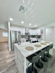 a kitchen with a large white island with stools at New modern centralized and lux home in Phoenix in Phoenix
