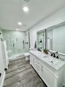 a white bathroom with two sinks and a shower at New modern centralized and lux home in Phoenix in Phoenix +41 photos