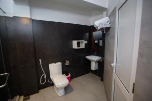 a bathroom with a toilet and a sink at Lucky Seven Hikkaduwa in Hikkaduwa
