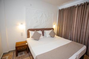 a bedroom with a bed with white sheets and pillows at Lucky Seven Hikkaduwa in Hikkaduwa
