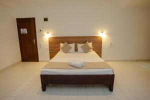 a bedroom with a large bed with white sheets and pillows at Lucky Seven Hikkaduwa in Hikkaduwa