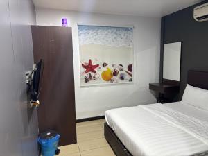 a bedroom with a bed and a painting on the wall at Happy Island Hotel in Pulau Ketam