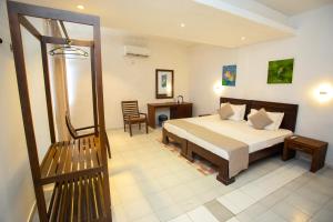 a bedroom with a bed and a desk and a chair at Lucky Seven Hikkaduwa in Hikkaduwa