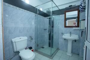 a bathroom with a shower and a toilet and a sink at Lucky Seven Hikkaduwa in Hikkaduwa