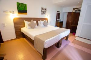 a bedroom with a large bed with white sheets and pillows at Lucky Seven Hikkaduwa in Hikkaduwa