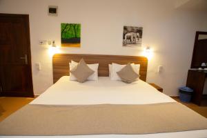 a bedroom with a bed with white sheets and pillows at Lucky Seven Hikkaduwa in Hikkaduwa