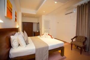 a hotel room with a bed and a chair at Lucky Seven Hikkaduwa in Hikkaduwa