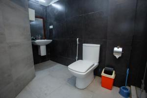 a bathroom with a white toilet and a sink at Lucky Seven Hikkaduwa in Hikkaduwa