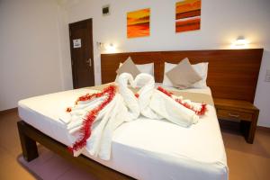 a bedroom with a bed with two towels on it at Lucky Seven Hikkaduwa in Hikkaduwa