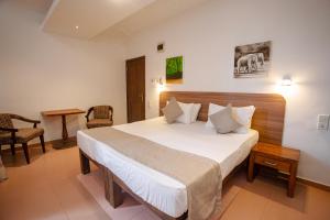 a bedroom with a large white bed in a room at Lucky Seven Hikkaduwa in Hikkaduwa