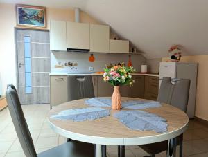a kitchen with a table with a vase of flowers on it at Moldo Residence in Ocna-Mureşului