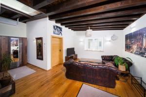a living room with a leather couch and a television at Apartment Black der Sportschule Badura in Leipzig