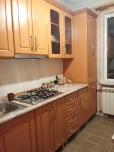 a kitchen with wooden cabinets and a stove at Sirik in Yerevan