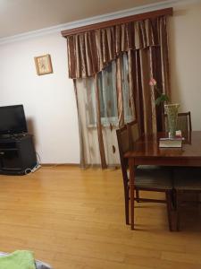 a living room with a table and a television and a table and chairs at Sirik in Yerevan