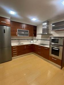 a large kitchen with wooden cabinets and stainless steel appliances at Piso Turístico Navarrete in Navarrete