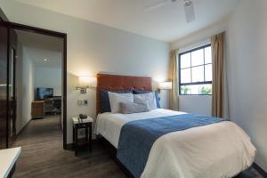 Un dormitorio con una cama grande y una ventana. en FlowSuites Polanco, en Ciudad de México