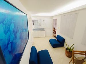 Il comprend un salon doté de fauteuils bleus et d'une télévision à écran plat. dans l'établissement Acogedores Apartaestudios en Getsemaní, à Carthagène des Indes