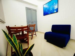 un salon avec une chaise bleue et une table dans l'établissement Acogedores Apartaestudios en Getsemaní, à Carthagène des Indes 28 autres photos