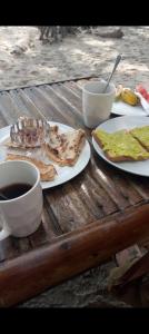 Tongwe Cultural Heritage Center في Katumbi: طاولة مع طبقين من الطعام وكوب من القهوة