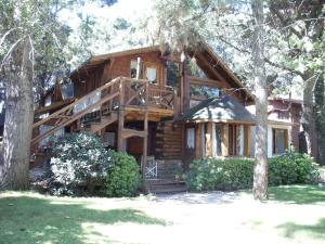 a log cabin in the woods with a large deck at Patagonia Playa Suites in Mar de las Pampas