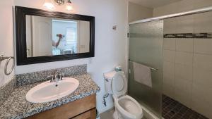 a bathroom with a sink and a toilet and a mirror at The Disney Hostel - Santa Ana in Santa Ana
