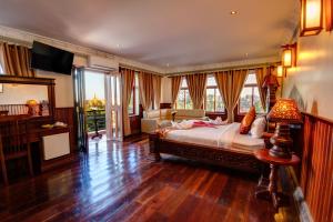 a bedroom with a bed and a couch and a television at Okay Boutique Hotel in Phnom Penh