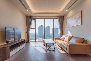 a living room with a couch and a flat screen tv at The Matrix One - Luxury free Gym&Pool in Hanoi