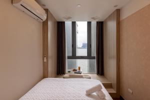 una camera da letto con un letto e una grande finestra di The Urban Tranquil a Hanoi