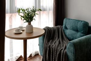 un tavolo, una sedia e un vaso con una pianta di The Urban Tranquil a Hanoi