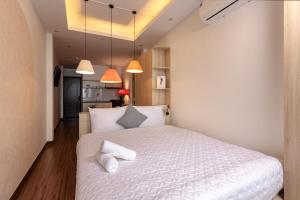 a bedroom with a white bed with two pillows at The Urban Tranquil in Hanoi