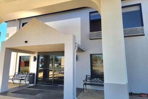 una casa bianca con una porta aperta e un patio di Days Inn & Suites by Wyndham New Iberia a New Iberia