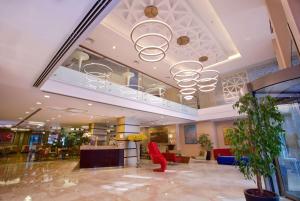 a lobby with a red chair and a chandelier at Ramada By Wyndham İstanbul Taksim in Istanbul