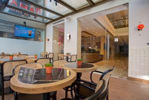 a restaurant with tables and chairs in a building at Ramada By Wyndham İstanbul Taksim in Istanbul